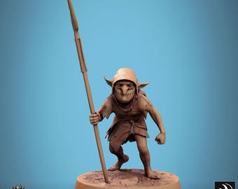 May include: A small, brown, goblin-like figure with a hood and a spear stands on a brown base. The figure has a mask-like face and is holding the spear in its right hand.