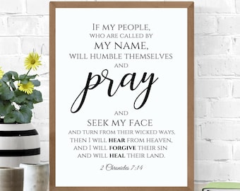May include: A white framed print with a black and white inspirational quote from the Bible, 2 Chronicles 7:14. The quote reads "If my people, who are called by my name, will humble themselves and pray and seek my face and turn from their wicked ways, then I will hear from heaven, and I will forgive their sin and will heal their land."