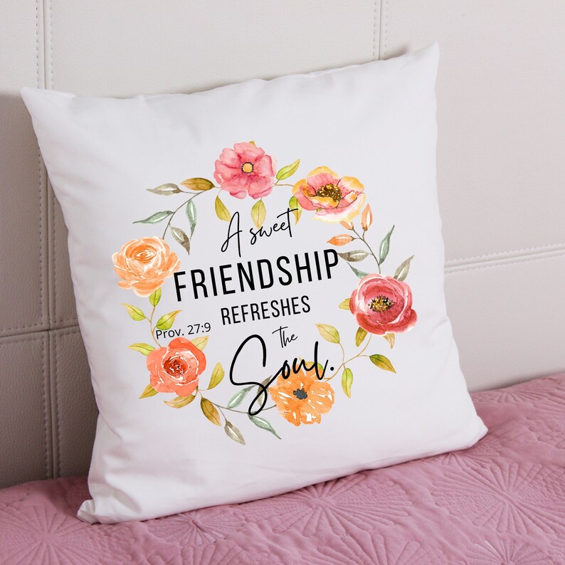 May include: White throw pillow with a floral wreath design and the text "A sweet FRIENDSHIP REFRESHES the Soul. Prov. 27:9"