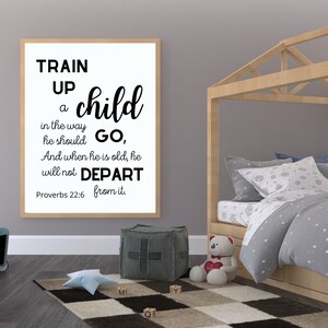 May include: Black and white typography print with the quote "Train up a child in the way he should go, and when he is old, he will not depart from it."  The quote is attributed to Proverbs 22:6. The print is hanging on a wall in a child's bedroom.