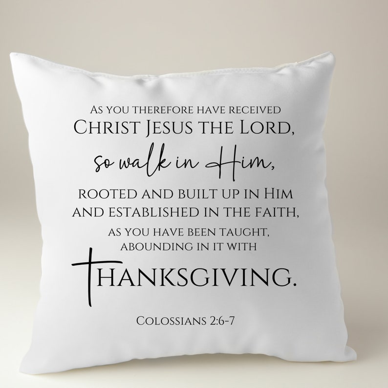 May include: White throw pillow with black text that reads "AS YOU THEREFORE HAVE RECEIVED CHRIST JESUS THE LORD, so walk in Him, ROOTED AND BUILT UP IN HIM AND ESTABLISHED IN THE FAITH, AS YOU HAVE BEEN TAUGHT, ABOUNDING IN IT WITH THANKSGIVING. COLOSSIANS 2:6-7"