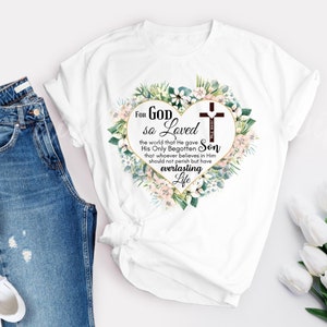 Peut inclure: T-shirt blanc avec un motif de c&oelig;ur floral et le texte "For God so Loved the world that He gave His Only Begotten Son that whoever believes in Him should not perish but have everlasting Life".