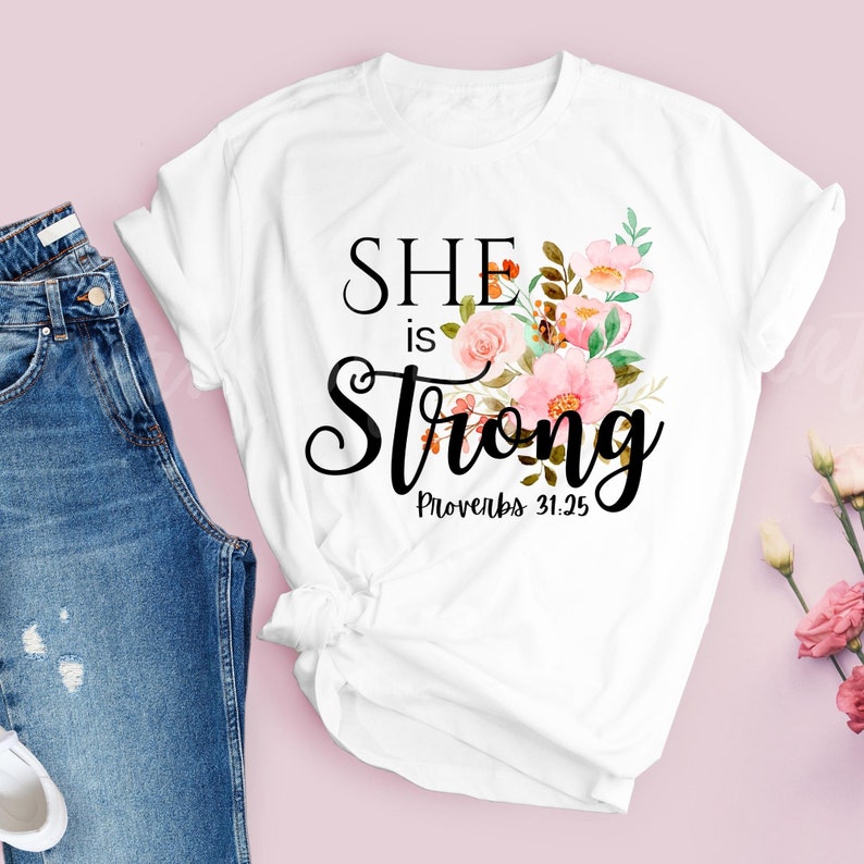 May include: White t-shirt with a floral design and the text "She is Strong Proverbs 31:25"