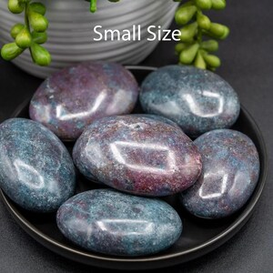 May include: A collection of small, polished stones in shades of teal, purple, and maroon, arranged on a black plate. The stones have a smooth, glossy finish. The text "Small Size" is visible above the stones.