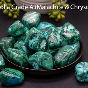 May include: A bowl of tumbled Mallacolla Grade A stones, a combination of Malachite and Chrysocolla. The stones are a vibrant green with blue and white swirls.