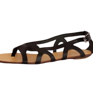 May include: Black leather sandals with a criss-cross strap design and an ankle strap with a buckle closure.