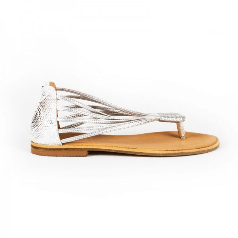 This is a strappy thong flat sandal for every occasion. This slides minimalist sandal is a nice choice for every type of foot. It is a slingback silver light sandal which goes perfectly with every outfit. It has zipper for easy placement