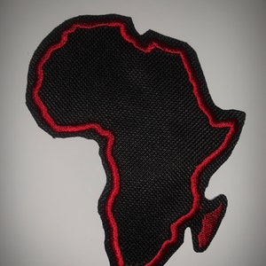 May include: Black fabric patch in the shape of the continent of Africa with a red embroidered outline.