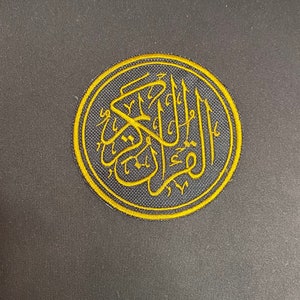 May include: A gold embroidered patch featuring the Arabic word "Allah" in a circular design on a black background.