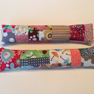 May include: Two colorful patchwork fabric catnip toys. The toys are long and rectangular, with a variety of patterns and colors, including red, pink, green, blue, and gray.