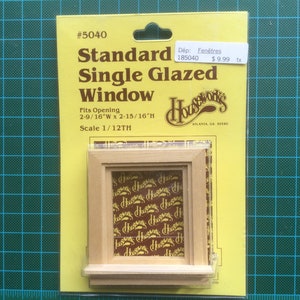 May include: A yellow package containing a wooden window frame for a dollhouse. The package is labelled "Standard Single Glazed Window" and "Scale 1/12TH". The window frame is 2-9/16 inches wide by 2-15/16 inches high.