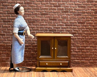 Wooden glass cabinet with two glass doors and one large functional drawer, with a fretwork base. 1:12 scale for dollhouses. 22302