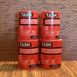 Peut inclure: Quatre rouleaux de papier abrasif à l'oxyde d'aluminium rouge et blanc. Chaque rouleau est étiqueté "TASK" et porte la taille "3 1/2" x 25'" et le grain imprimé sur l'étiquette.