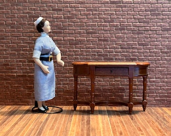 Half-moon console table in burgundy wood, with turned legs, fretwork crossbar, and one working drawer. 1:12 scale for dollhouses. 20403.