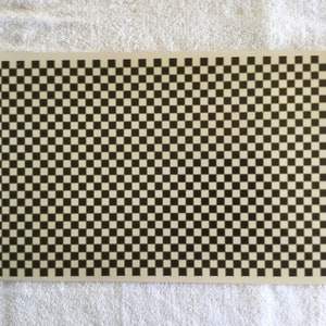 Peut inclure: Un motif à carreaux noirs et blancs sur un fond beige. Le motif est composé de petits carrés.