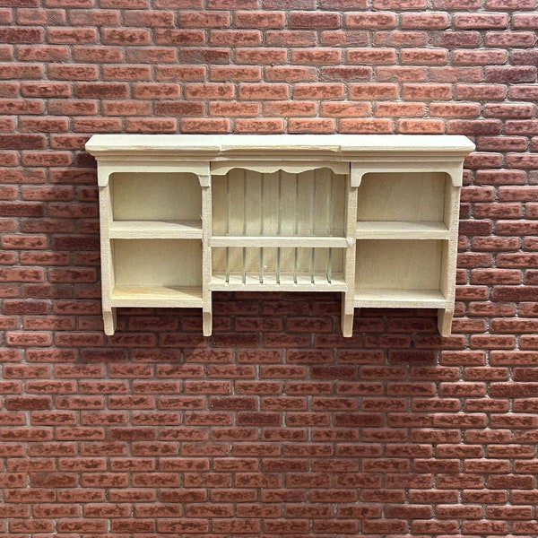Vintage style wooden wall shelf. 1/12 Scale in unpainted wood. Molded and scrolled top, 4 shelves and separator for plates. 10803.