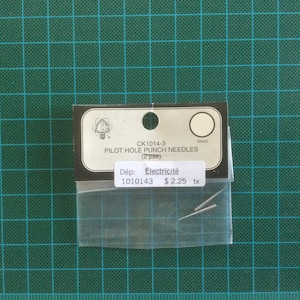 May include: A pack of two silver pilot hole punch needles, labelled "CK1014-3 PILOT HOLE PUNCH NEEDLES (2 pack)" and "Dép: Électricité 1010143 $2.25 tx".