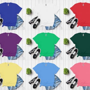 K&ouml;nnte beinhalten: Neun farbige T-Shirts in verschiedenen Farben wie Blau, Wei&szlig;, Rot, Lila, Gr&uuml;n und Gelb werden pr&auml;sentiert. Jedes Shirt wird mit Jeansshorts und schwarzen Sneakers kombiniert. Die Shirts sind auf einer wei&szlig;en Holzoberfl&auml;che angeordnet.