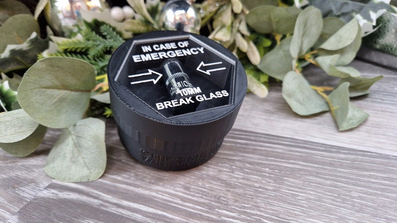 May include: A black hexagonal break glass alarm with a clear plastic cover and the text "IN CASE OF EMERGENCY TURN BREAK GLASS" printed on it.