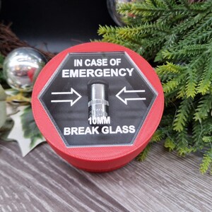 May include: Red hexagonal break glass emergency box with a clear plastic cover and a silver metal striker. The box has the text "IN CASE OF EMERGENCY" and "10MM BREAK GLASS" printed on it.