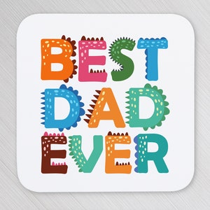 以下が含まれることがあります： 恐竜のようなデザインのカラフルな漫画風文字で「BEST DAD EVER」と書かれた白いコースターです。