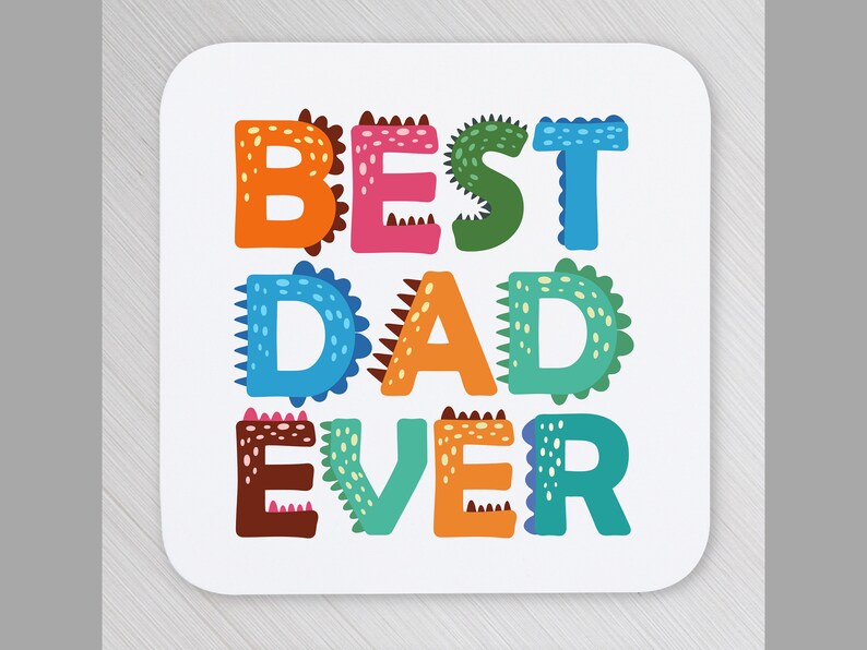 以下が含まれることがあります： 恐竜のようなデザインのカラフルな漫画風文字で「BEST DAD EVER」と書かれた白いコースターです。