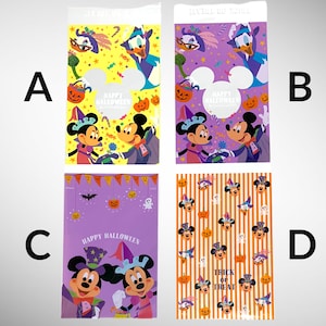 May include: Four different Halloween-themed plastic bags with Mickey Mouse and Minnie Mouse characters. The bags are purple, orange, and yellow with various Halloween designs. The text on the bags reads "Happy Halloween" and "Trick or Treat".