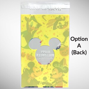May include: A yellow plastic bag with a Mickey Mouse head cutout. The bag has a colorful Halloween design with Mickey Mouse, Donald Duck, and other characters. The text "Happy Halloween" is printed in white on the bag.