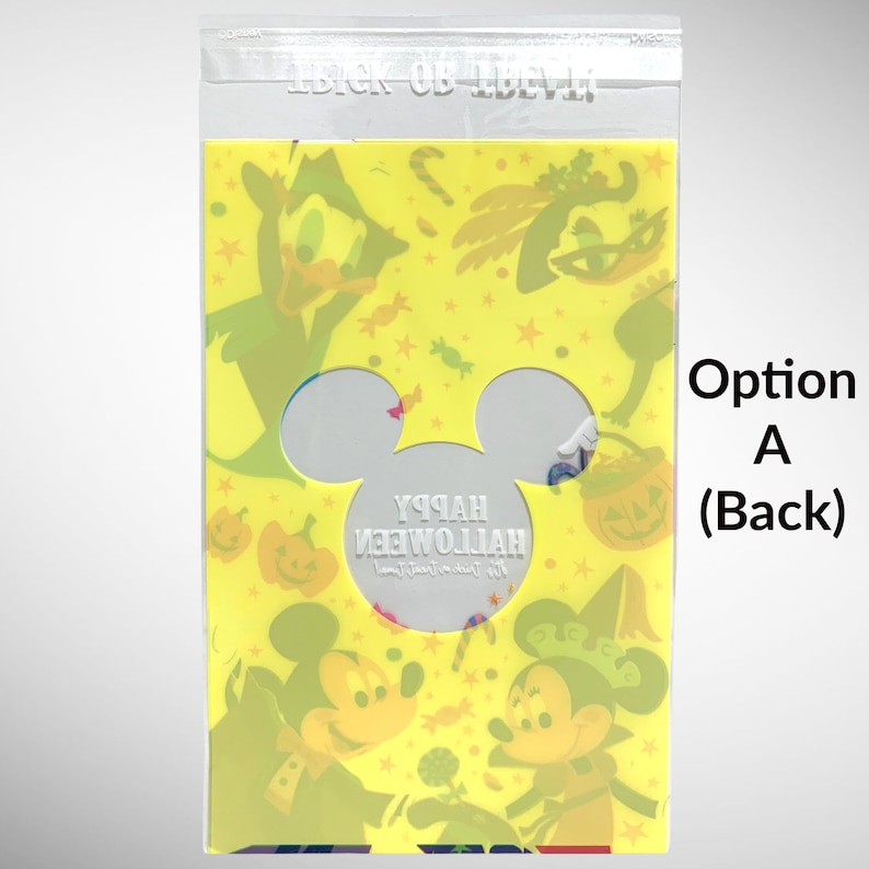 May include: A yellow plastic bag with a Mickey Mouse head cutout. The bag has a colorful Halloween design with Mickey Mouse, Donald Duck, and other characters. The text "Happy Halloween" is printed in white on the bag.