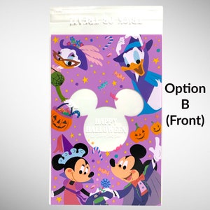 May include: A purple plastic bag with a clear front panel. The bag features a Halloween-themed design with Mickey Mouse, Minnie Mouse, and Donald Duck dressed in costumes. The text "Happy Halloween" is printed in white on a white Mickey Mouse head silhouette.