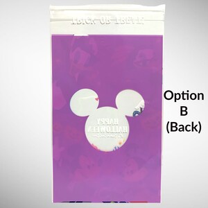May include: Purple plastic bag with a Mickey Mouse head cutout. The cutout reveals a white background with the text "Happy Halloween" in white lettering. The bag has a zipper closure at the top.