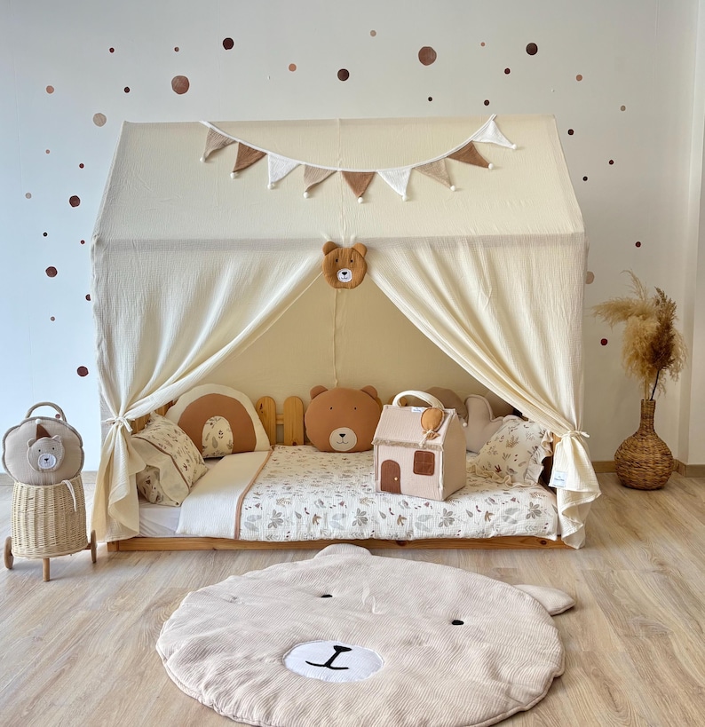 Muslin canopy draped over toddler floor bed in cozy kids room