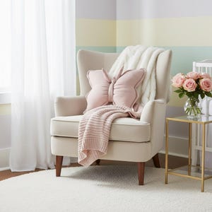 Pink butterfly decorative pillow on cream armchair, handmade nursery cushion for baby girl room, soft cotton butterfly kids decor