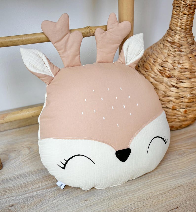 Handmade deer nursery pillow with woodland animal design in neutral colors for baby room decor