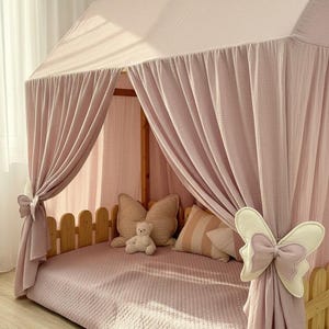 Muslin fabric canopy over reading pillows