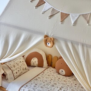 Muslin canopy draped over toddler floor bed in cozy kids room