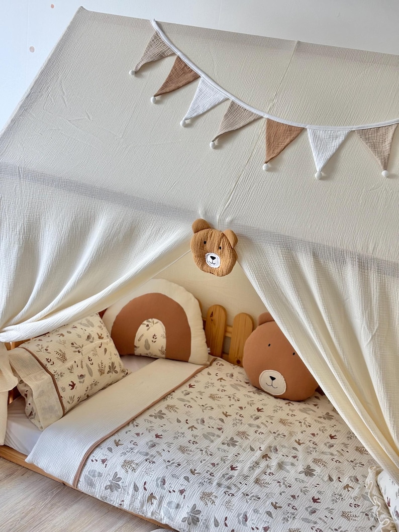 Muslin canopy draped over toddler floor bed in cozy kids room
