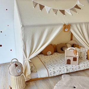 Muslin canopy draped over toddler floor bed in cozy kids room