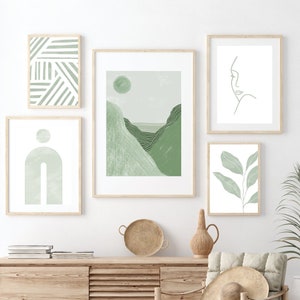 Gallery wall art set of 5 digital prints in sage green. The designs include a stripes print, a mid century modern rainbow, an abstract landscape, a leaves print and a line drawing of a woman's face.