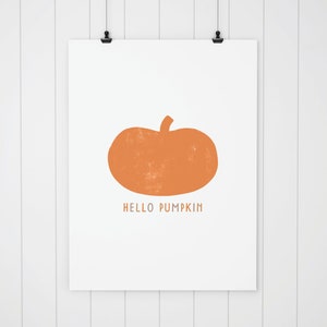 Może przedstawiać: Biała, drukowana grafika z pomarańczową sylwetką dyni i tekstem "HELLO PUMPKIN".