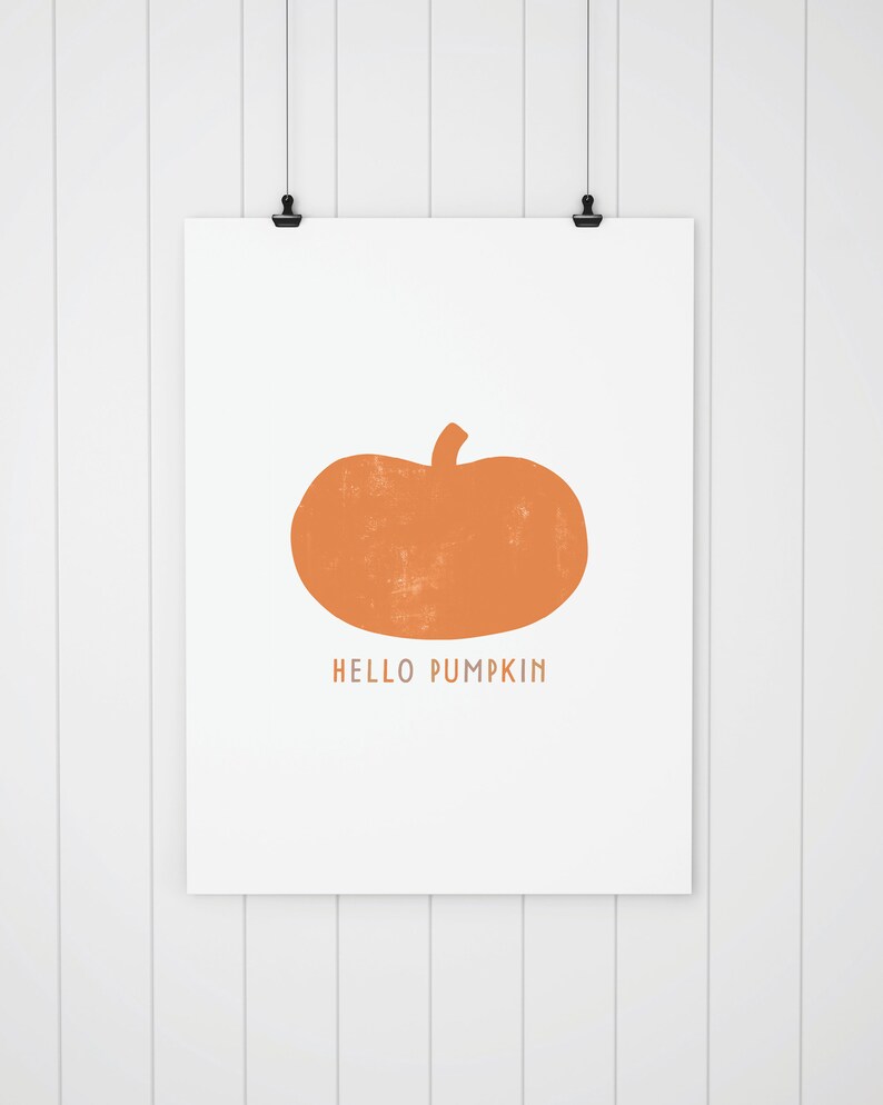 Może przedstawiać: Biała, drukowana grafika z pomarańczową sylwetką dyni i tekstem "HELLO PUMPKIN".