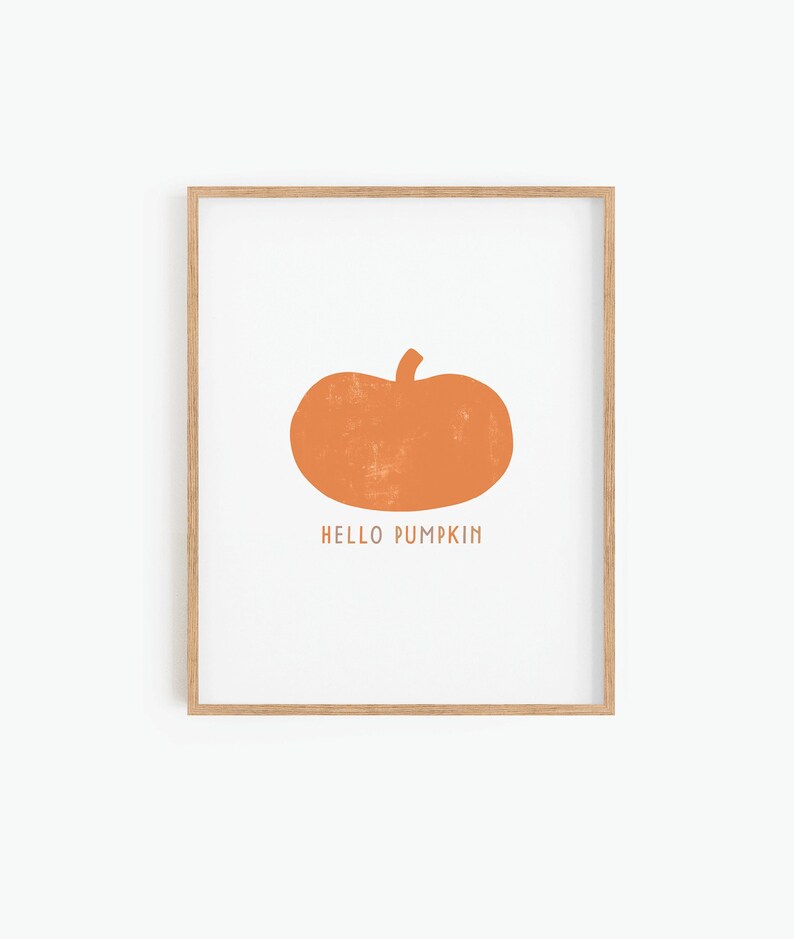 Może przedstawiać: Wydruk w ramie z prostą ilustracją pomarańczowej dyni i tekstem "HELLO PUMPKIN" w kolorze białym.