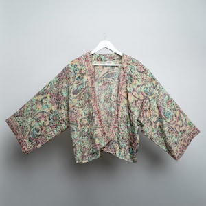 Peut inclure: Un kimono à manches longues et à la coupe ample, avec un motif de couleur vert clair, rose et bleu.