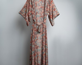 May include: A long, red, blue and cream paisley patterned robe with a tie belt.