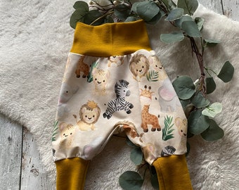 Puede incluir: Pantalones de bebé amarillos y blancos con estampado de animales de safari. Los pantalones tienen una cintura y puños de color amarillo mostaza.