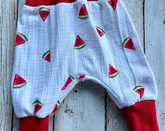 Puede incluir: Pantalones de bebé blancos con estampado de sandía y cintura y puños elásticos rojos.