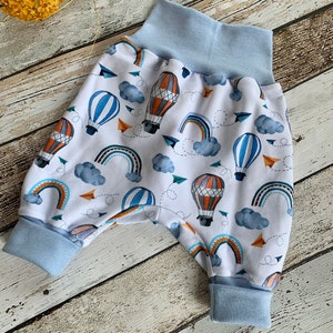Puede incluir: Pantalones de beb&eacute; blancos con cintura y pu&ntilde;os azules. Los pantalones tienen un estampado colorido de globos aerost&aacute;ticos, arco&iacute;ris y nubes.