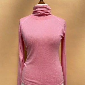 Op de afbeelding: Een roze longsleeve trui met een hoge hals op een wit mannequins.