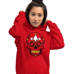 May include: Red hoodie with a white and red sugar skull design. The skull has a floral pattern and black eyes.