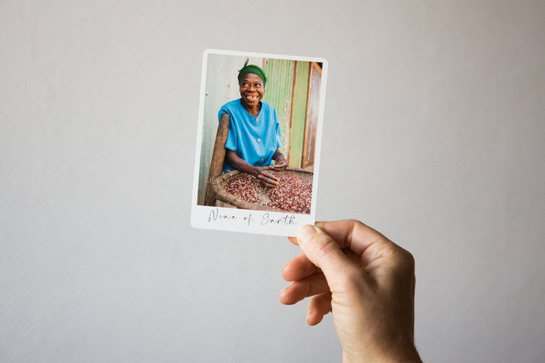 May include: A woman in a blue shirt and green headwrap smiles while sorting red coffee beans in a basket. The image is captioned "Wine of Earth."